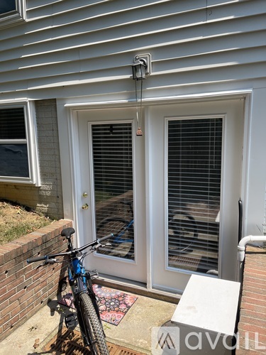 A bicycle is parked on a brick wall next to a house.