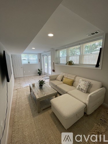 A living room with a white couch and a wooden coffee table.