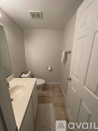 A bathroom with a toilet, sink, and mirror.
