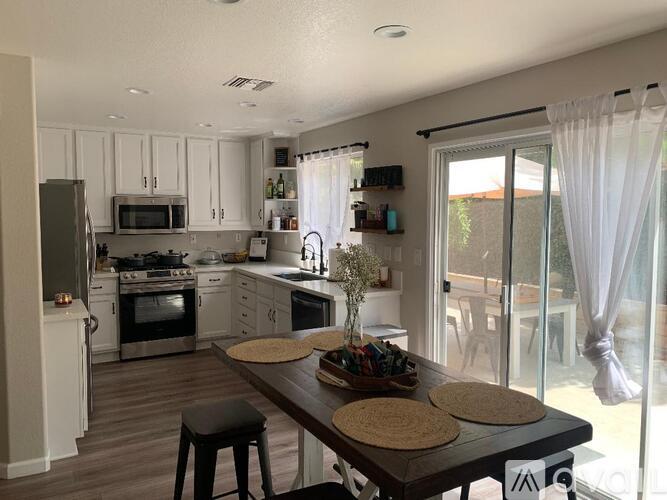 A kitchen with a table and chairs in front of a window.