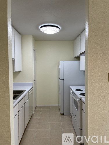 A kitchen with white appliances and cabinets.