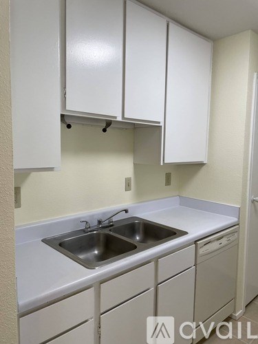A kitchen with white cabinets and a sink.
