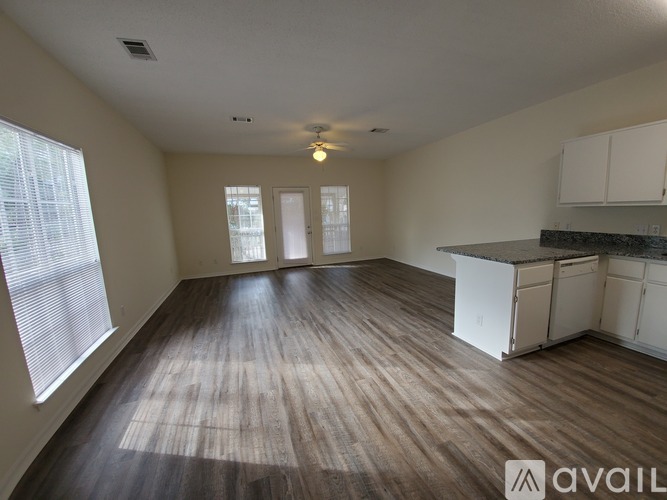 A spacious room with wooden floors and white walls.
