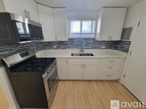 A kitchen with white cabinets and a black stove top oven.