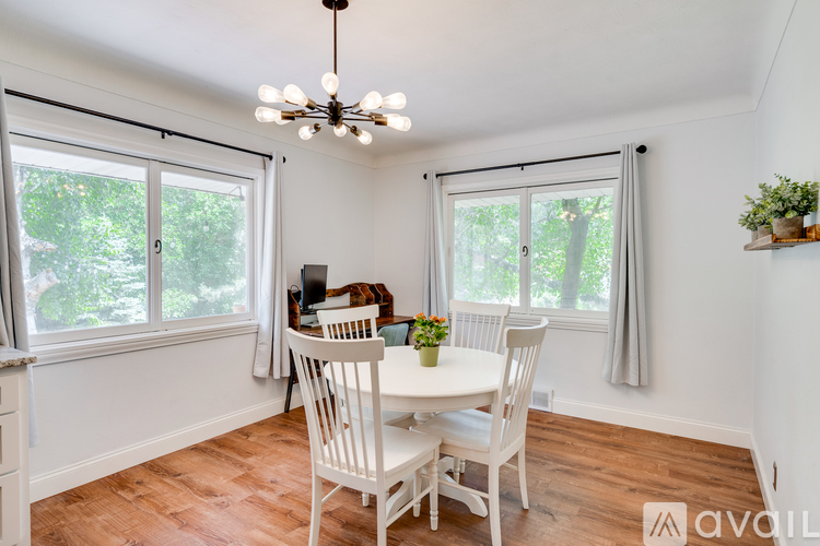A dining room with a table and chairs.
