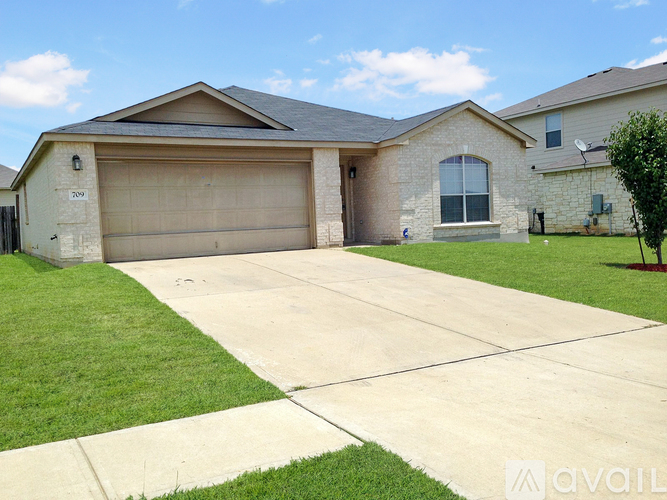 A house with a garage and a driveway in front.
