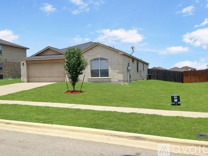 A house with a brown roof and a green lawn in front.