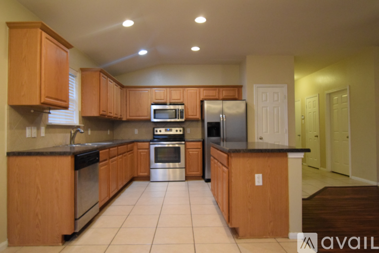 A kitchen with wooden cabinets and a black countertop.