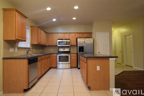 A kitchen with wooden cabinets and a black countertop.