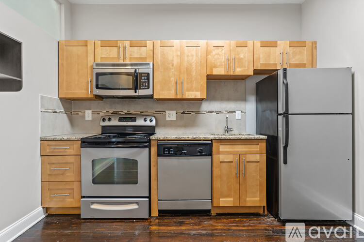 A kitchen with wooden cabinets and a stainless steel refrigerator.