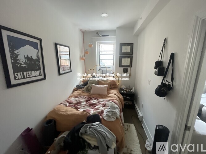 A bedroom with a bed in the center and a poster on the wall.