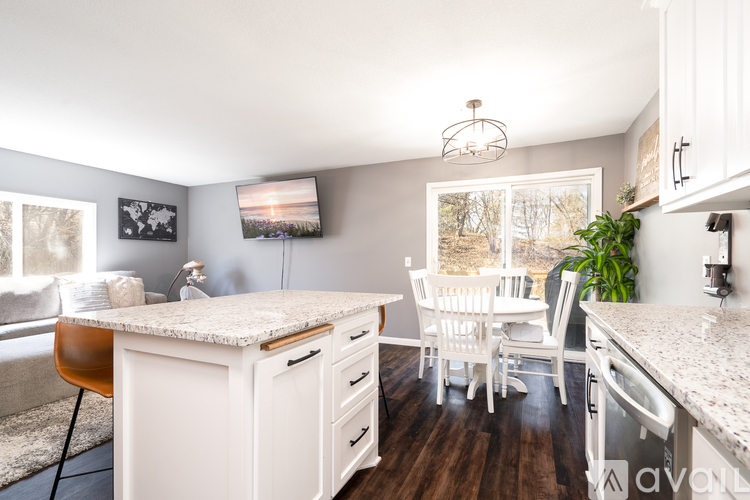 A kitchen with white cabinets and a granite countertop.