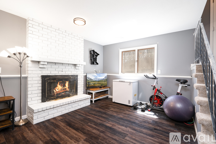 A living room with a fireplace and exercise equipment.