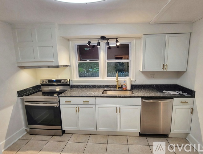 A kitchen with white cabinets and a black countertop.