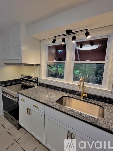 A kitchen with a sink, stove, and oven.