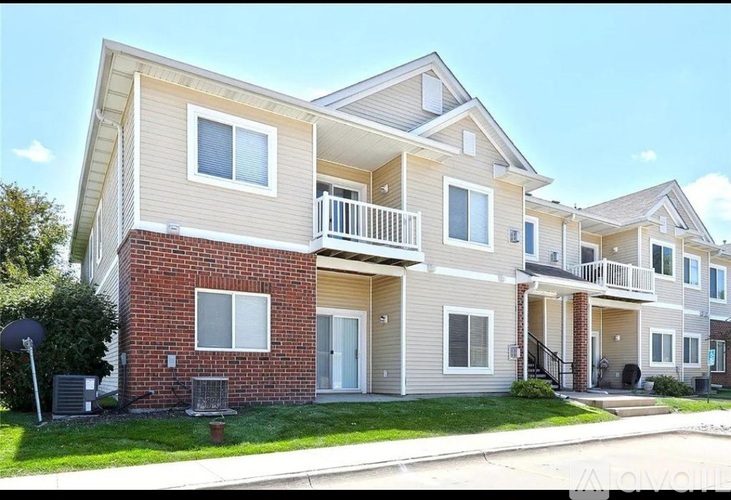 A two-story apartment building with a balcony on the second floor.