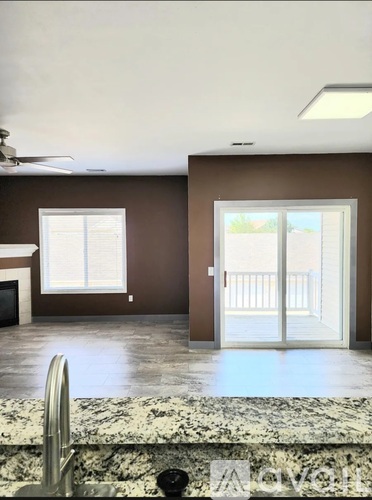 A kitchen with a marble counter top and a ceiling fan.