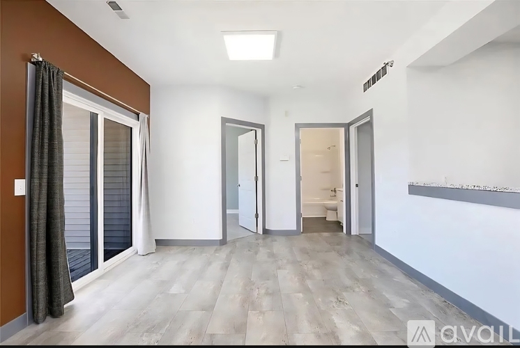 A spacious room with a sliding door and a mirror on the wall.