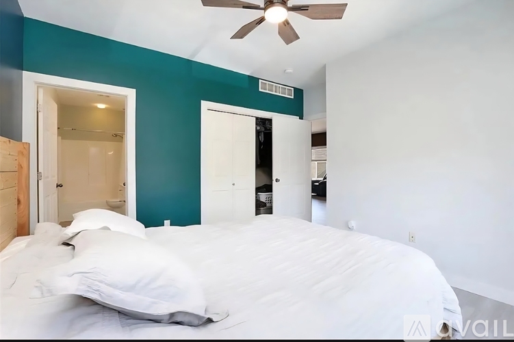 A bedroom with a bed and a ceiling fan.