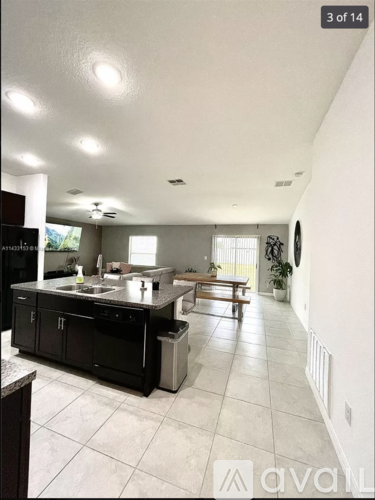 A kitchen with black cabinets and a tiled floor.