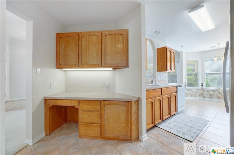 A kitchen with wooden cabinets and a white countertop.