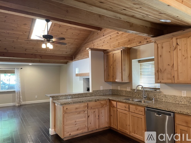 A kitchen with wooden cabinets and a granite countertop.