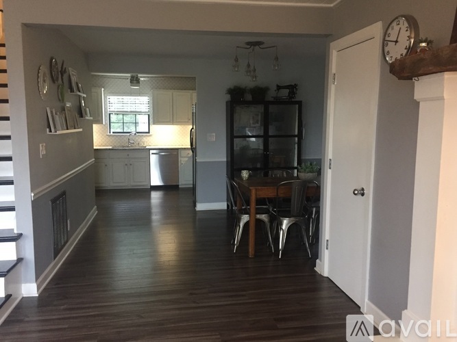 A kitchen with a dining table and chairs in the middle of the room.
