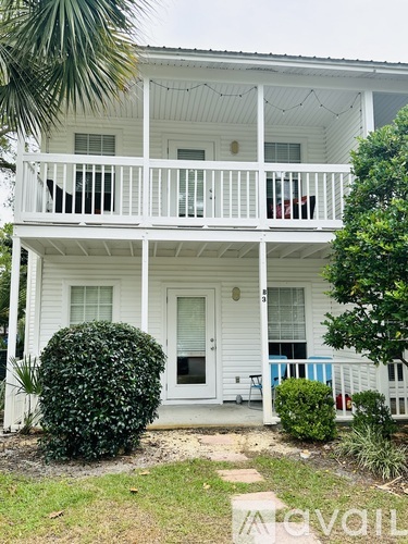 A white house with a balcony and a door.