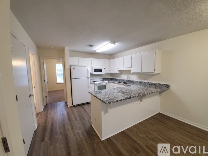 A kitchen with white cabinets and a granite countertop.
