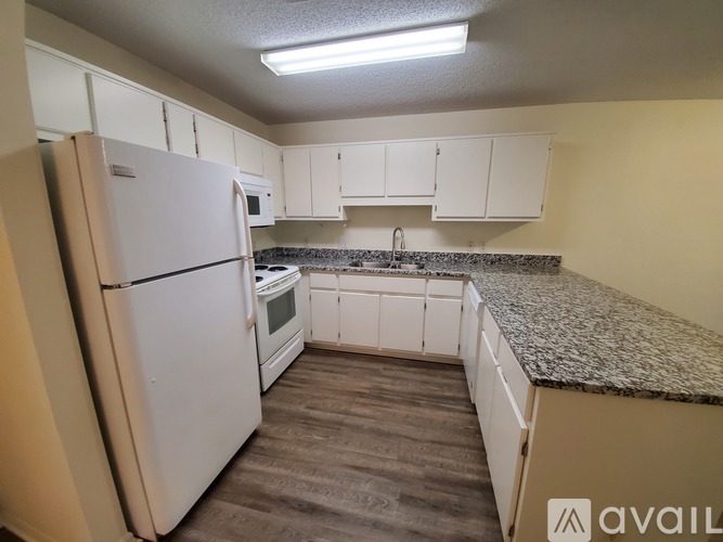 A kitchen with white appliances and cabinets.