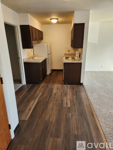 A kitchen with wooden floors and white appliances.