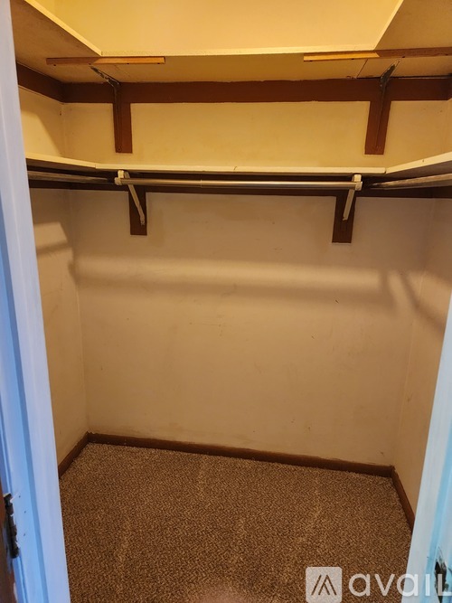 A small, empty room with a carpeted floor and a door on the left.
