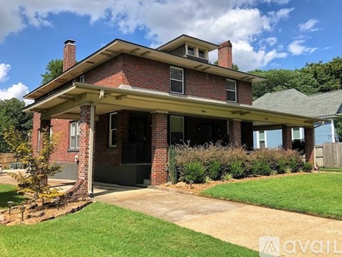 A brick house with a porch and a covered entrance.