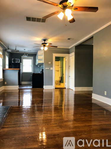 A room with a ceiling fan and wooden floors.