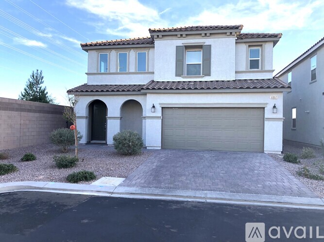 A house with a garage and a driveway in front of it.