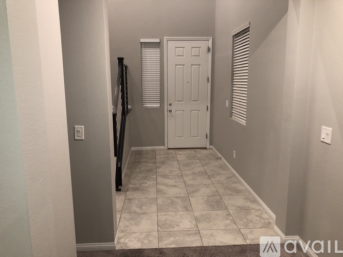 A hallway with a white door and a black tripod.