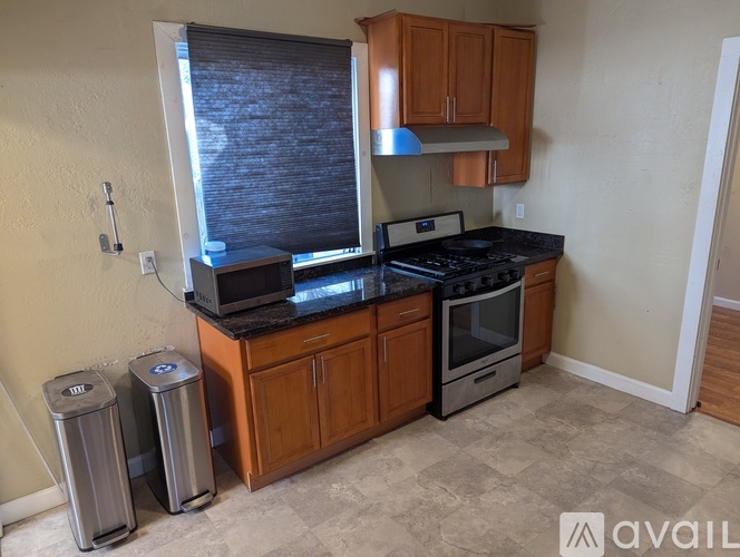 A kitchen with a black countertop and wooden cabinets.