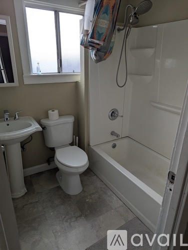 A bathroom with a toilet, sink, and bathtub.