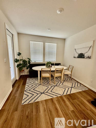 A dining room with a wooden table and chairs.