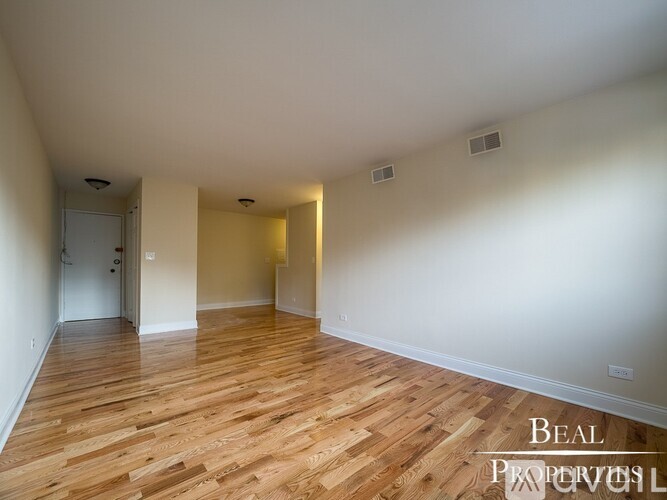A room with wooden flooring and a white ceiling.