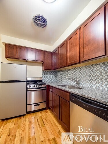 A kitchen with wooden cabinets and a stainless steel dishwasher.