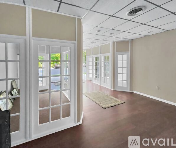 A room with a rug on the floor and a door on the left.