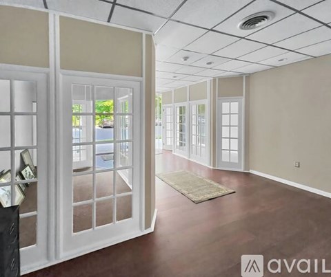 A room with a rug on the floor and a door on the left.