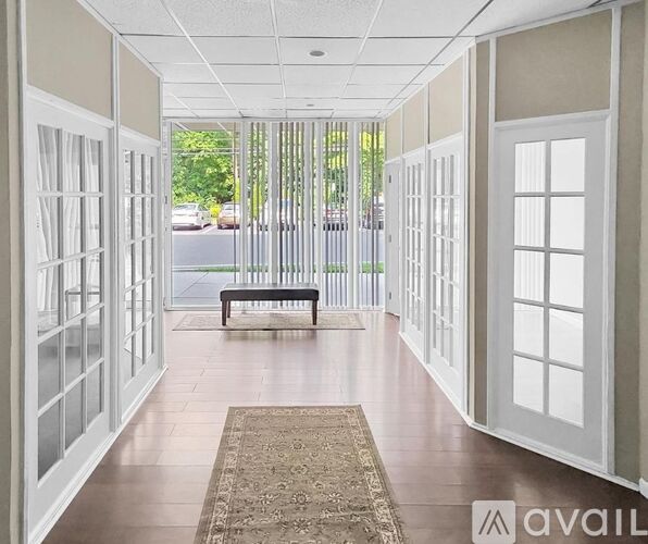 A hallway with white doors and a bench in the middle.
