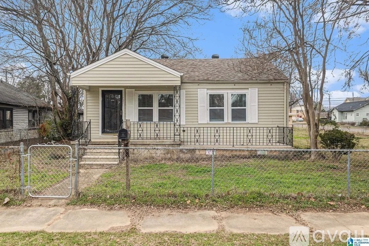 A small house with a fence in front of it.