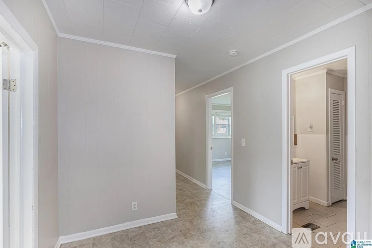 A spacious, empty room with a doorway leading to another room.