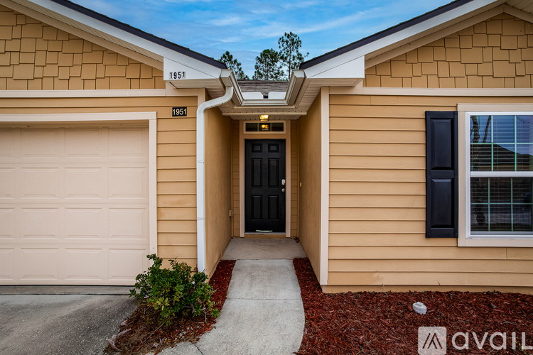 A house with a garage door and a black door is for sale.