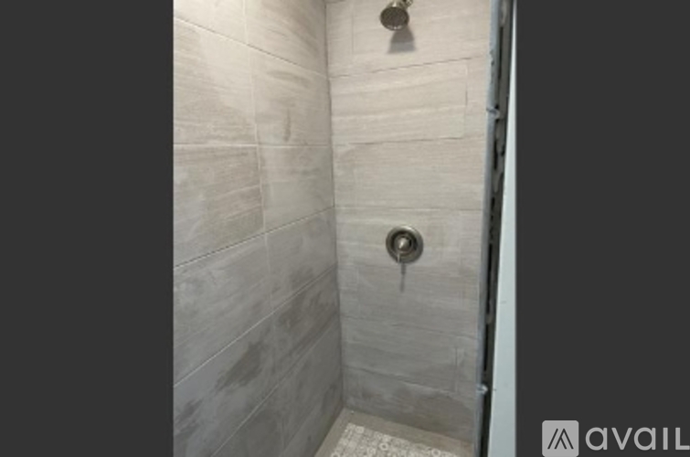 A bathroom with a shower and a drain.
