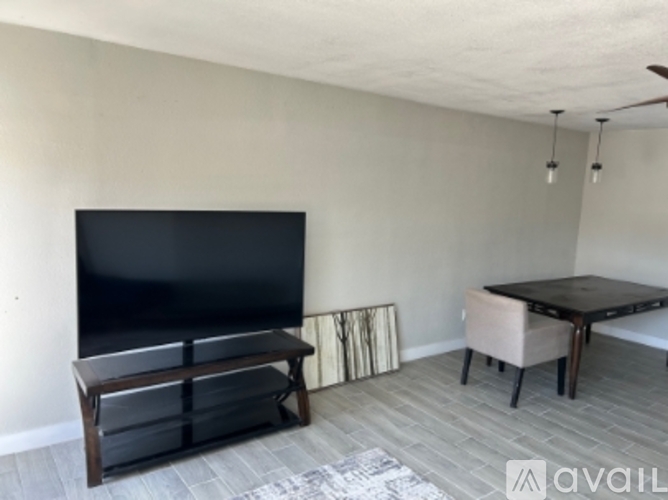 A living room with a black television and a wooden bench.