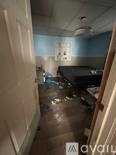 A room with a bed and a trash can is shown.